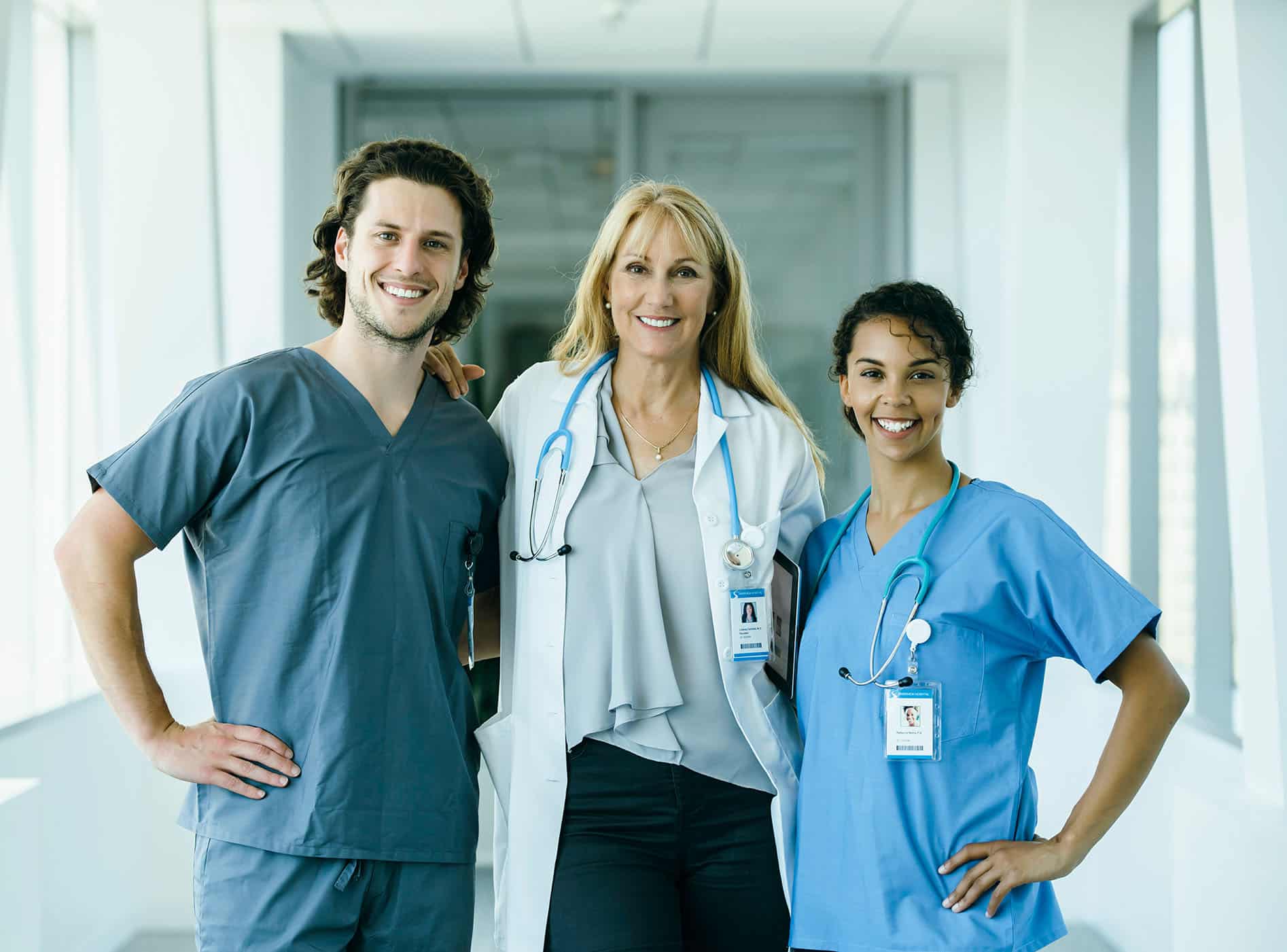 Nurses and doctor pose in hospital hallway